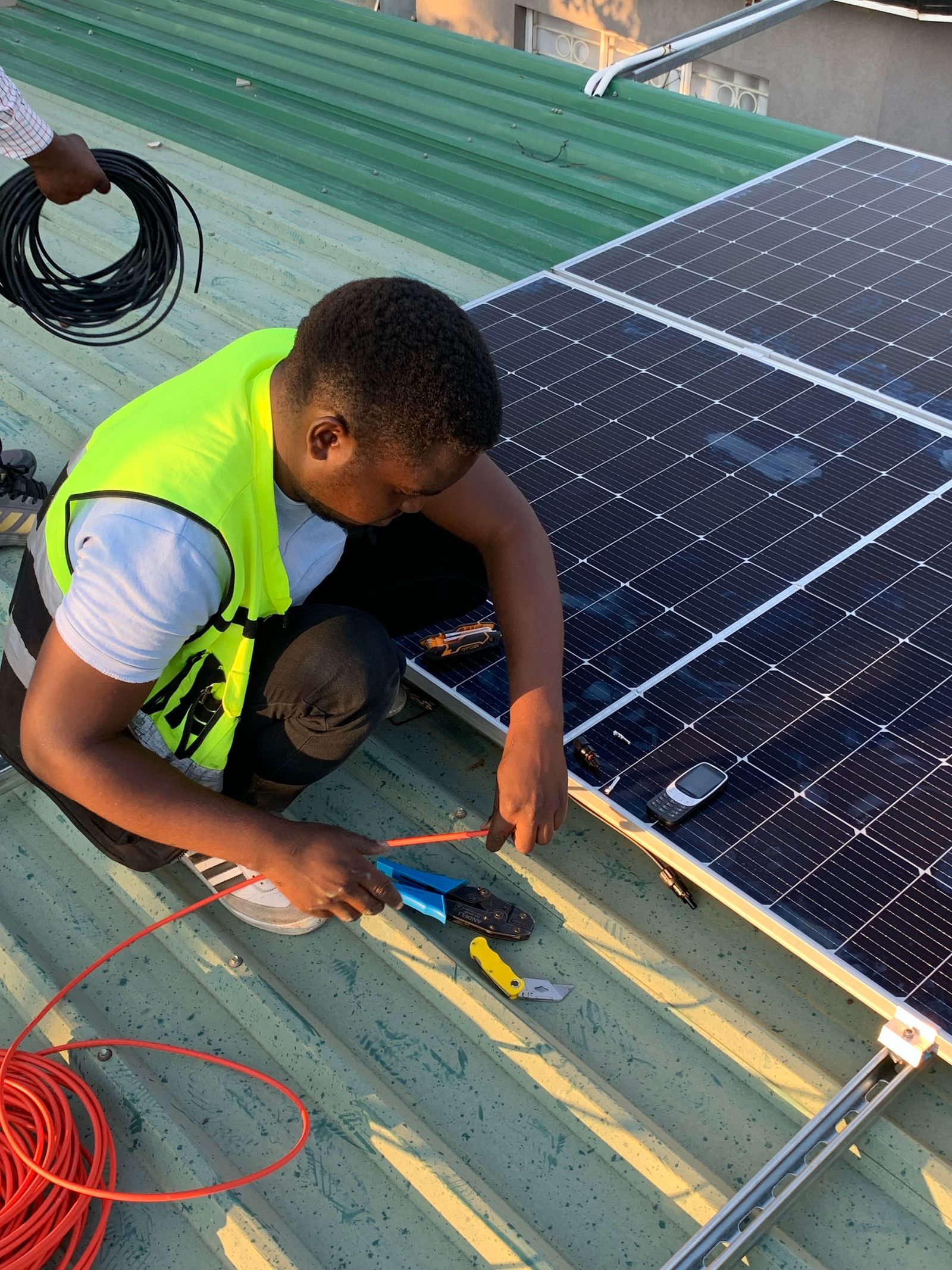 A Gulam Energy technician installing solar panels on a rooftop